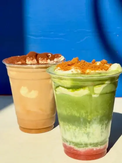 Two iced drinks topped with cream and crumble