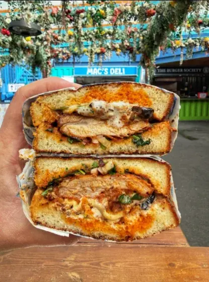 A sandwich cut in half and held up to the camera